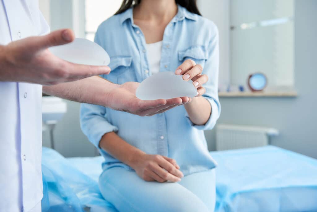 Woman examines breast implants during a breast augmentation consultation