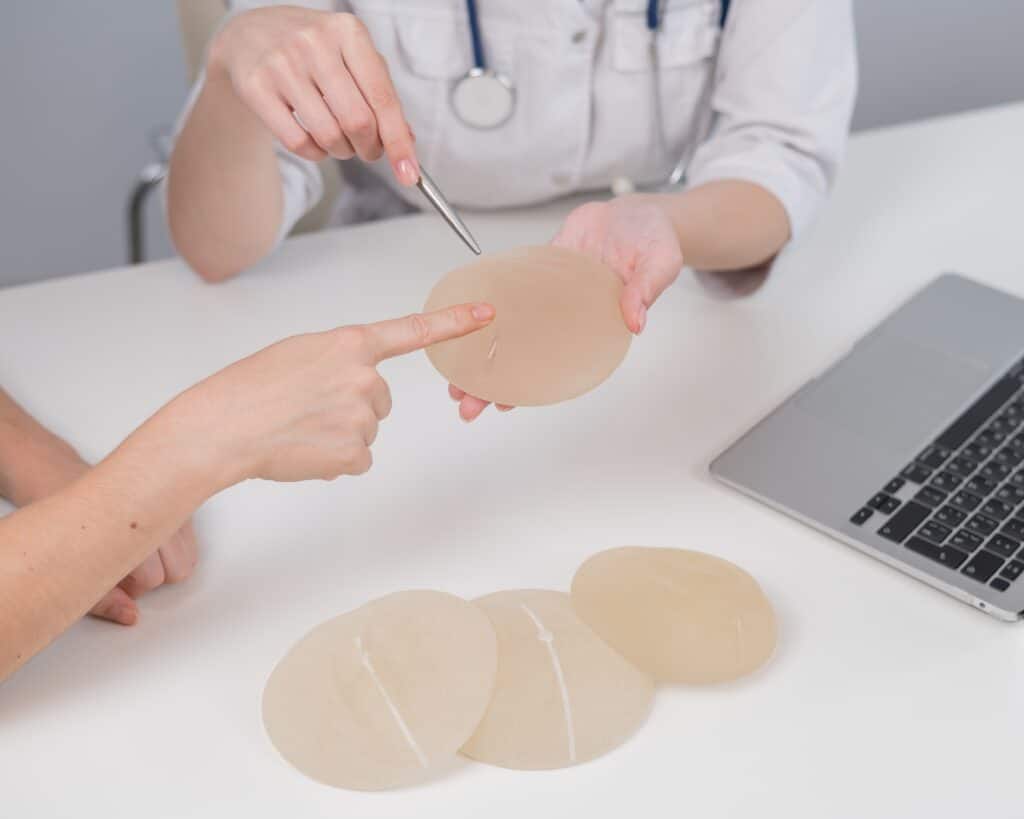Woman and her doctor discuss changing implant size before a breast augmentation revision procedure