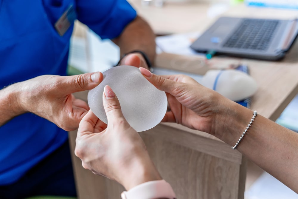 Woman holds a silicone breast implant as she decides the right size for her breast implants in Boca Raton